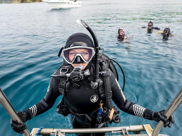 Cold water scuba diver with other divers