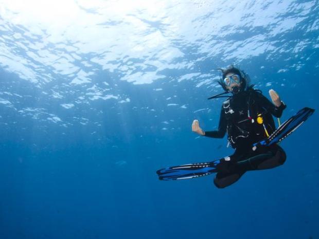 Diver sitting cross-legged in the ocean.