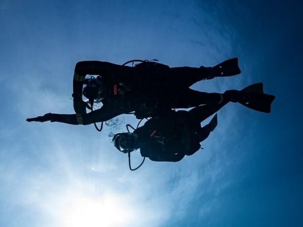 scuba divers using a compass